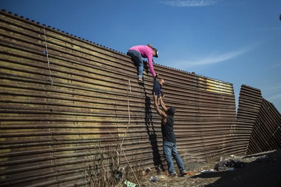 Central American migrants climb the border fence between Mexico and the United States, near El Chaparral border crossing, Tijuana, Baja California, Mexico, on November 25, 2018. Central American migrants climb the border fence between Mexico and the United States, near El Chaparral border crossing, Tijuana, Baja California, Mexico, on November 25, 2018.