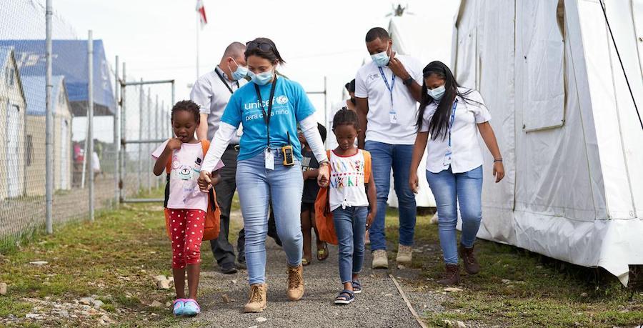 Two unaccompanied Haitian migrant girls are accompanied by a UNICEF staff member on their way to reunite with their parents, after transiting through the Darien jungle, in Panama.
