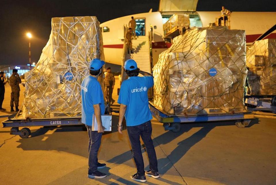 On Sept. 4, 2022, UNICEF Logistics Associate Jamal Nasir, left, and UNICEF Communication Officer Moeed Hussain observe the unloading of UNICEF’s humanitarian supplies for flood-affected people in Pakistan from a special chartered flight at the Karachi Airport.
