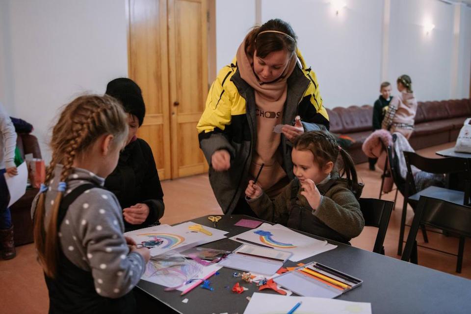 During an air raid, children at the Spilno center in Balakliya, Ukraine, move to a safer space and continue working on their art projects.