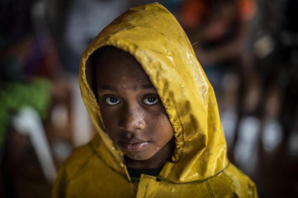A girl protects herself from the heavy rains by wearing a raincoat as she returns home from a UNICEF-supported shelter after the passage of Hurricane Iota swept through Bilwi, Nicaragua, in November 2020.