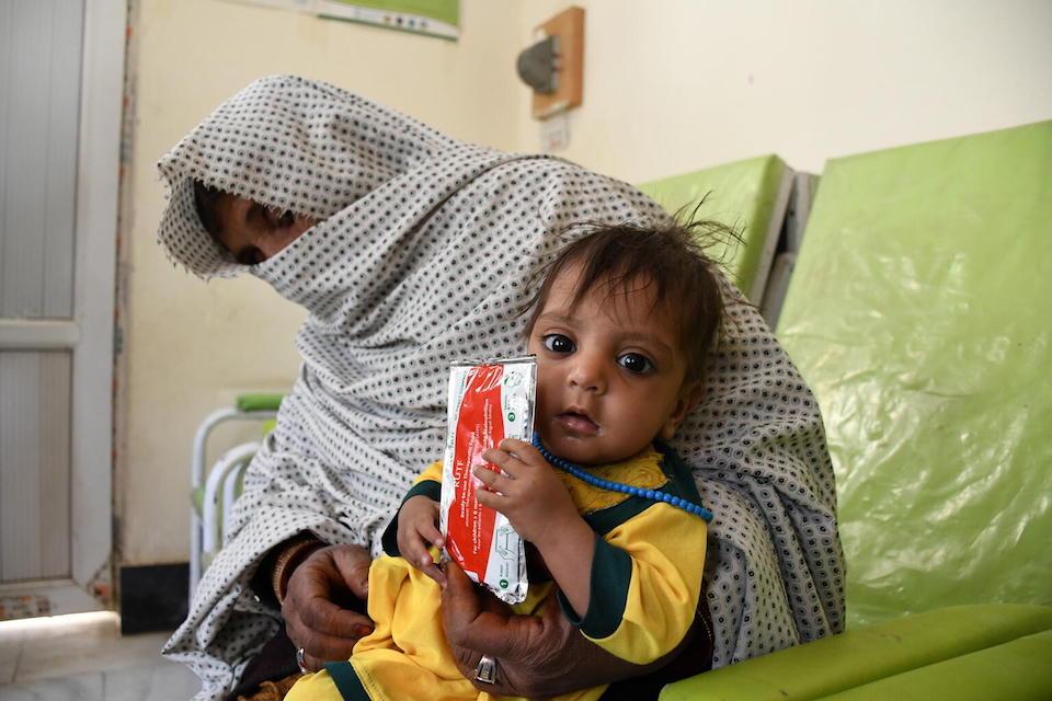 Fatima, 11 months old, holds a packet of Ready-to-Use Therapeutic Food at UNICEF-supported Speen Boldak hospital in Kandahar province, southern Afghanistan. 