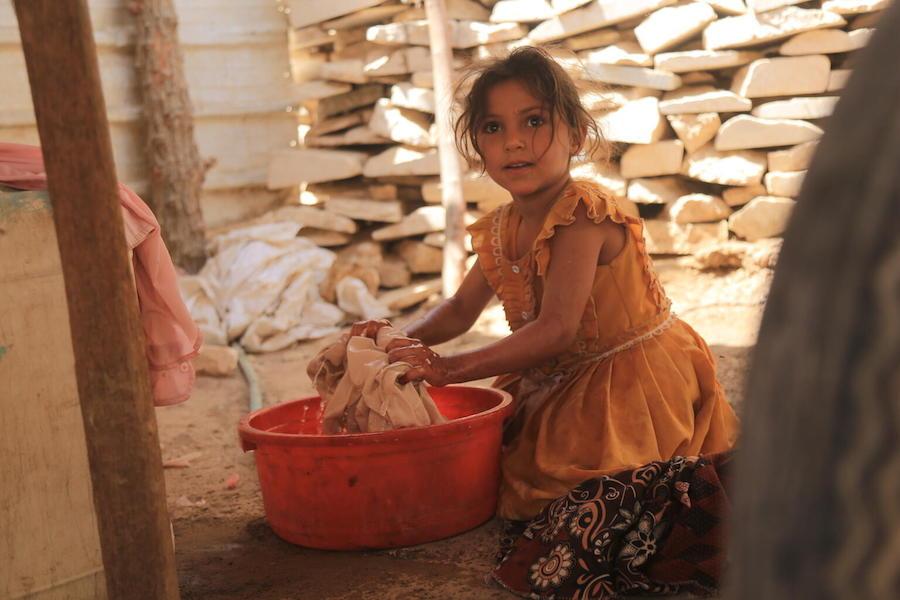 Hilalah, 6, washes clothes near the tent where she has lived with her family for the past five years in Al-Jufainah IDP camp, Marib, Yemen.