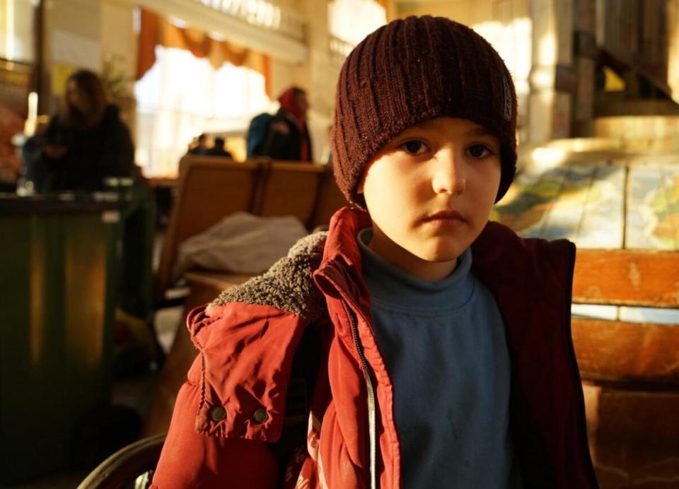 7-year-old Maksym wears a red winter coat and dark red cap.