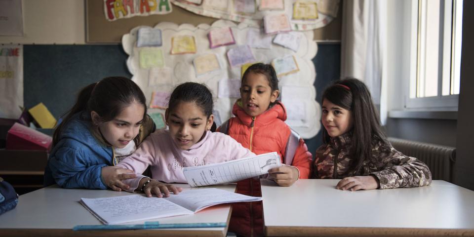Nine-year-old Syrian refugee Badiaa (second left) sits at a desk with Italian and Syrian friends in her classroom at a public elementary school in Trento, Trentino province, Italy, Tuesday 2 May 2017. Badiaa, who is originally from Homs, Syria, arrived from Lebanon through a UNICEF-supported humanitarian corridor that helped 93 Syrian refugees reach Italy safely in February 2016.