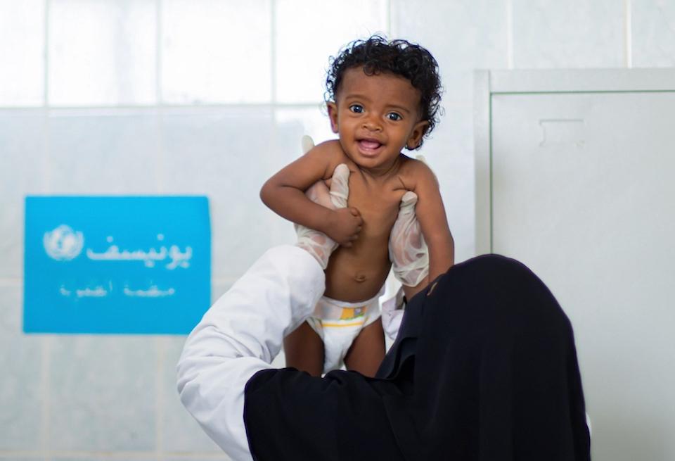 Health worker Hana’a holds 8-month old Jouri at a UNICEF-supported health facility in Hudaydah, Yemen, where Jouri and other children suffering from severe acute malnutrition are receiving lifesaving treatment.