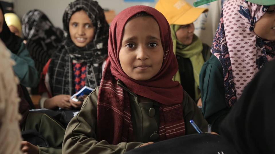 A student receives learning materials as part of a Back to School support program in Yemen.