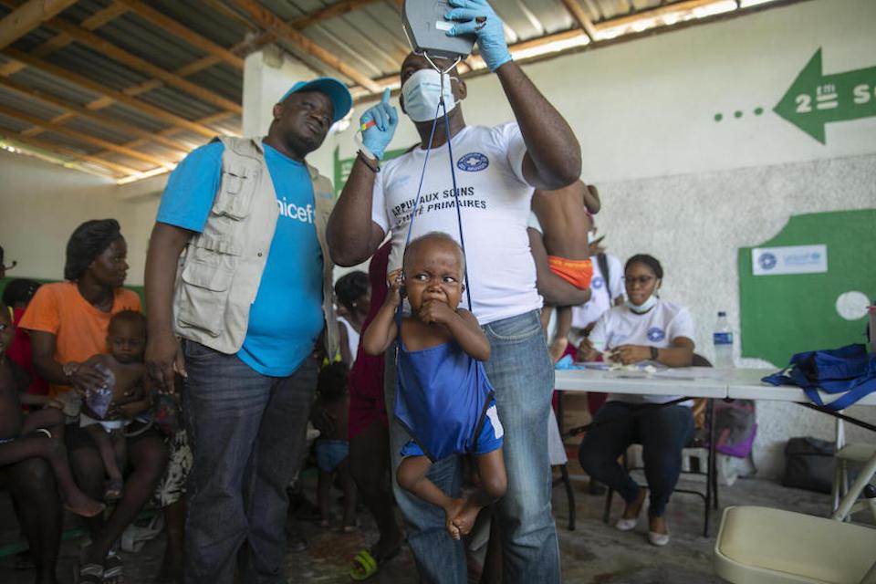 A 2-year-old boy gets weighed at a malnutrition clinic run by UNICEF in Cité Soleil, Haiti, on Oct. 16, 2022.