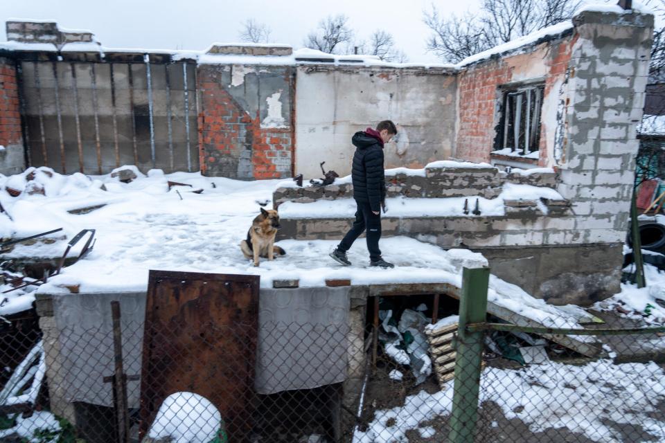 A boy walks in the snow around the remains of his family home in Irpin, Ukraine.