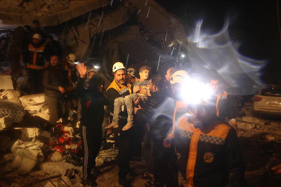 Rescue workers carry a boy from earthquake debris in Dana, Idlib, Syria on Feb. 6, 2023.