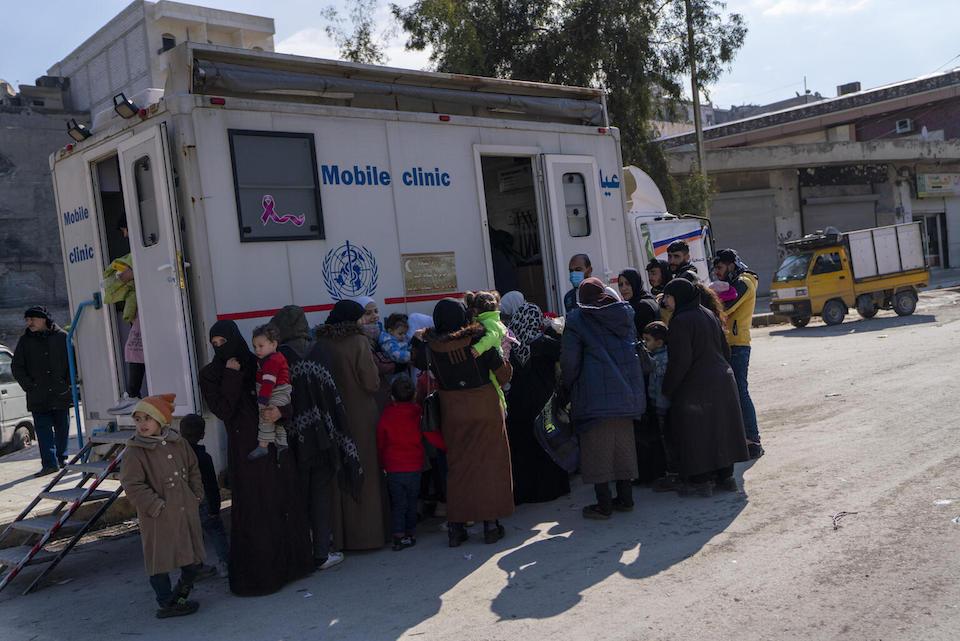 Parents and children wait to see a UNICEF-supported health team at a mobile clinic in the city of Aleppo, northwest Syria. 