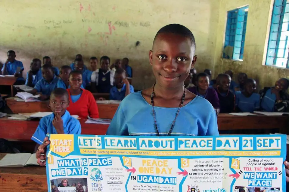 Ritah Sharon Bira, a P.4 pupil of Buhundu Primary School in Bukonzo sub-county, Bundibugyo District, Western Uganda, displays a peace poster to assist pupils in her class learn about the International Day of Peace observed annually on Sept. 21.
