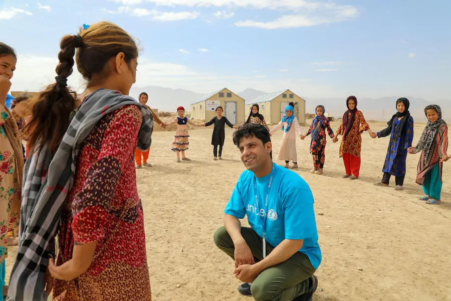 Hashmat Latifi, a UNICEF child protection officer, engages with kids at a Child-Friendly Space at the Ferdousi camp for displaced families in the Nahri Shahi district of Balkh province, northern Afghanistan.