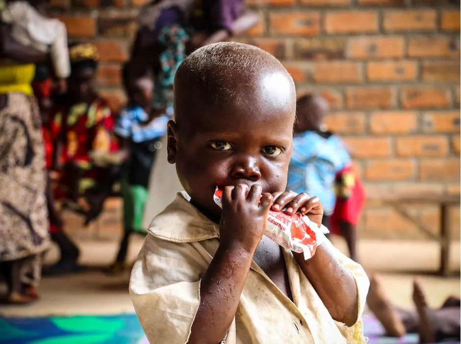 At a UNICEF-supported treatment center outside Bangui, Central African Republic, a young boy is given Ready-to-Use Therapeutic Food, a highly-effective treatment for severe acute malnutrition.