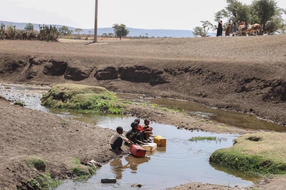 Children fill jerry cans with contaminated water from the Mena River in Ethiopia's Oromia Region.