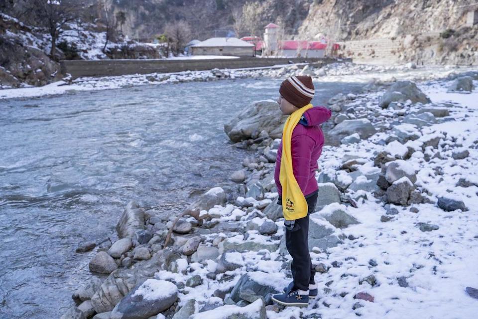 Noorullah, 10, stands on the bank of River Panjkora next to his house in Sulool Daramdala village, Upper Dir District, Khyber Pakhtunkhwa, Pakistan.