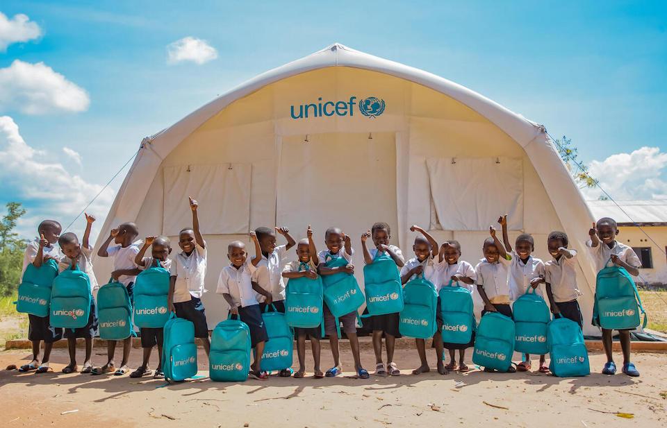 Students holding UNICEF backpages outside Kibi Primary School, Lumfukwe village in Tanganyika province, Democratic Republic of the Congo.