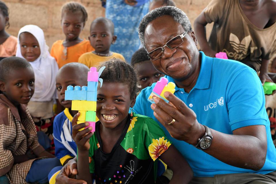 Salimata, 8, and a UNICEF staff member build with blocks at a Child-Friendly Space in Wedbare, north central Burkina Faso.