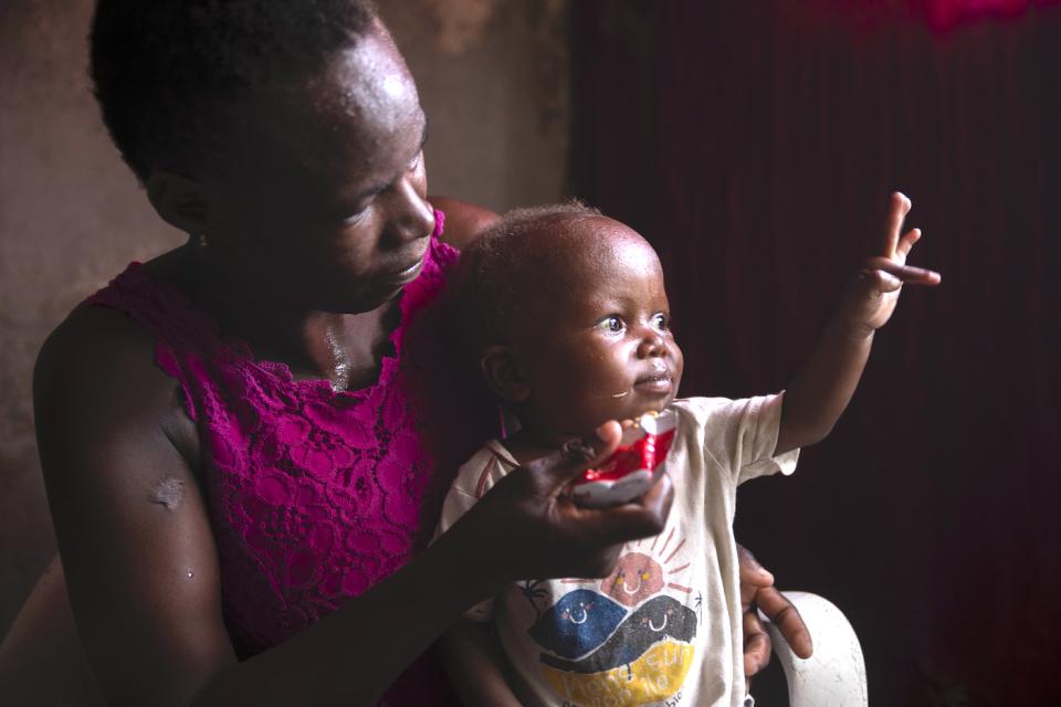 A mom in Cité Soleil, Haiti, feeds her 2-year-old son Ready-to-Use Therapeutic Food (RUTF) provided by UNICEF to treat severe acute malnutrition, which is common among children living in poverty.