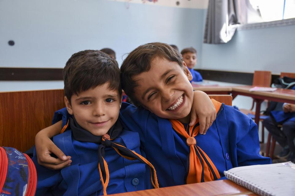 Seven-year-olds Karam, left, and Mohamed look forward to their Arabic lessons in a newly rehabilitated school in Zamalka, rural Damascus, Syria. 