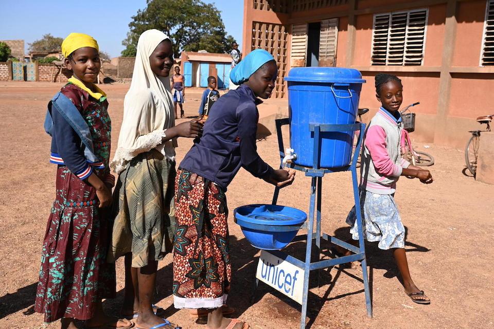 Children wash hands outside their school in Dedougou, west Burkina Faso, where UNICEF helped install a solar-powered water system.