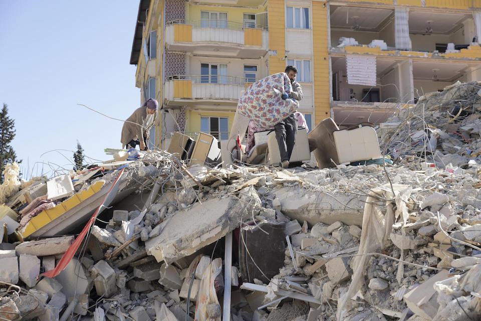 In Gaziantep, Turkey, survivors search for blankets in the rubble of a building that collapsed after earthquakes on Feb. 6, 2023.