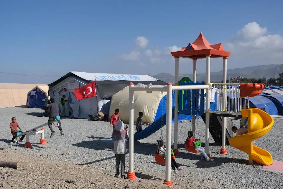 On March 4, 2023 in Antakya, Hatay Province, Turkey, children play outside a UNICEF tent at a camp for families displaced by the earthquakes.