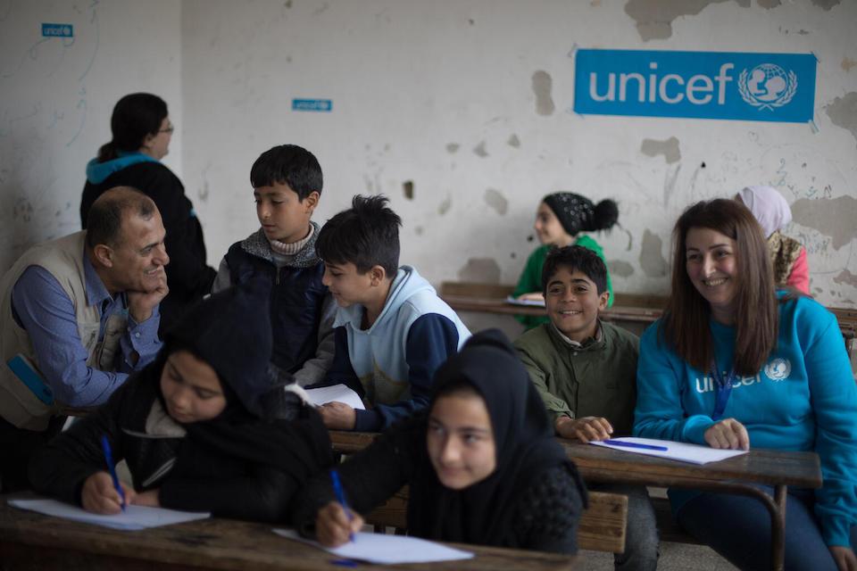 UNICEF staff attend a math class for 4th and 5th graders at a school being used as a shelter for families displaced by earthquakes in the Southern Ramel area of Syria's Latakkia governorate on Feb. 22, 2023.