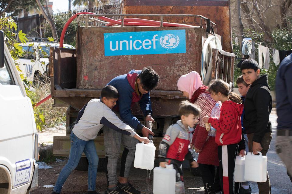 Children sheltering at the Albasel Centre in Lattakia governorate, Syria, fill water jugs at a UNICEF water truck on February 20, 2023.