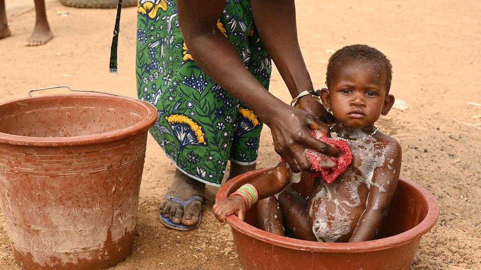 A mother washes her baby in the village of Nambekaha, in northern Côte d’Ivoire.