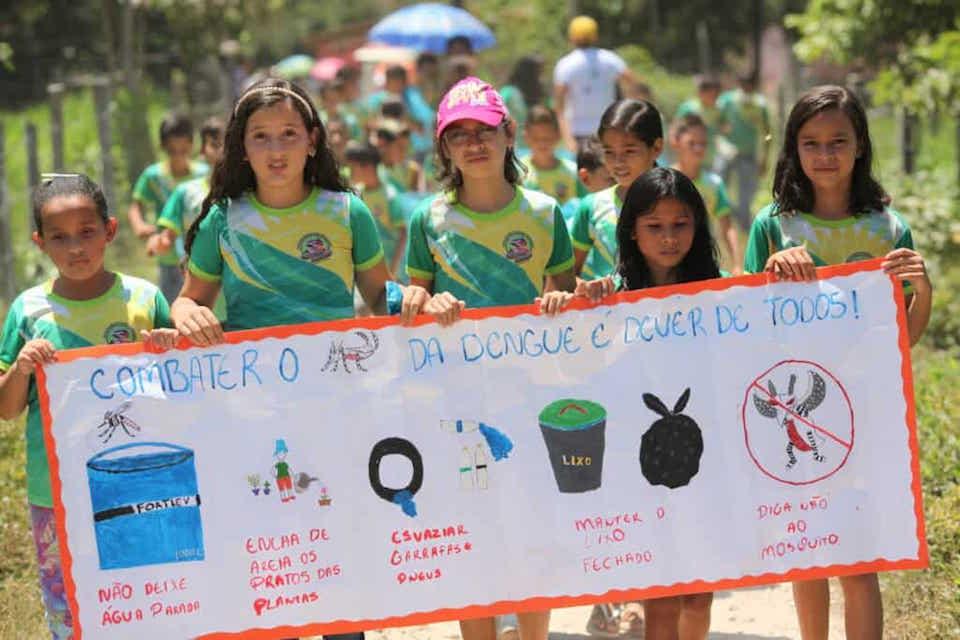 In Brazil, children carry a poster with information on how to prevent dengue fever.