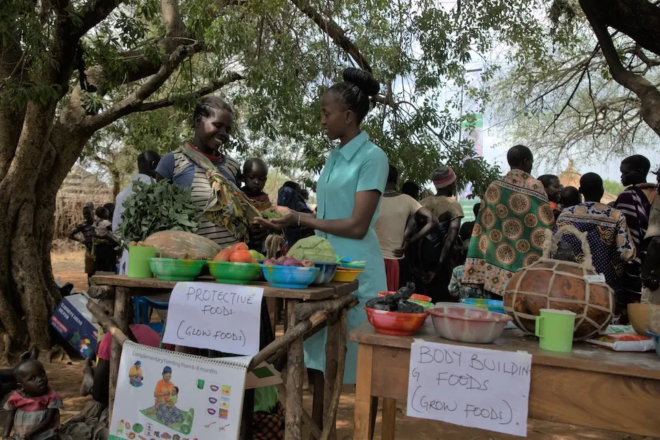 A health worker in Karamoja, Uganda, shares information at a monthly nutrition community outreach session.