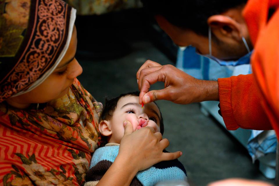 A child receives a Vitamin A supplement from Ajmal, a polio vaccinator in Lahore, Pakistan.