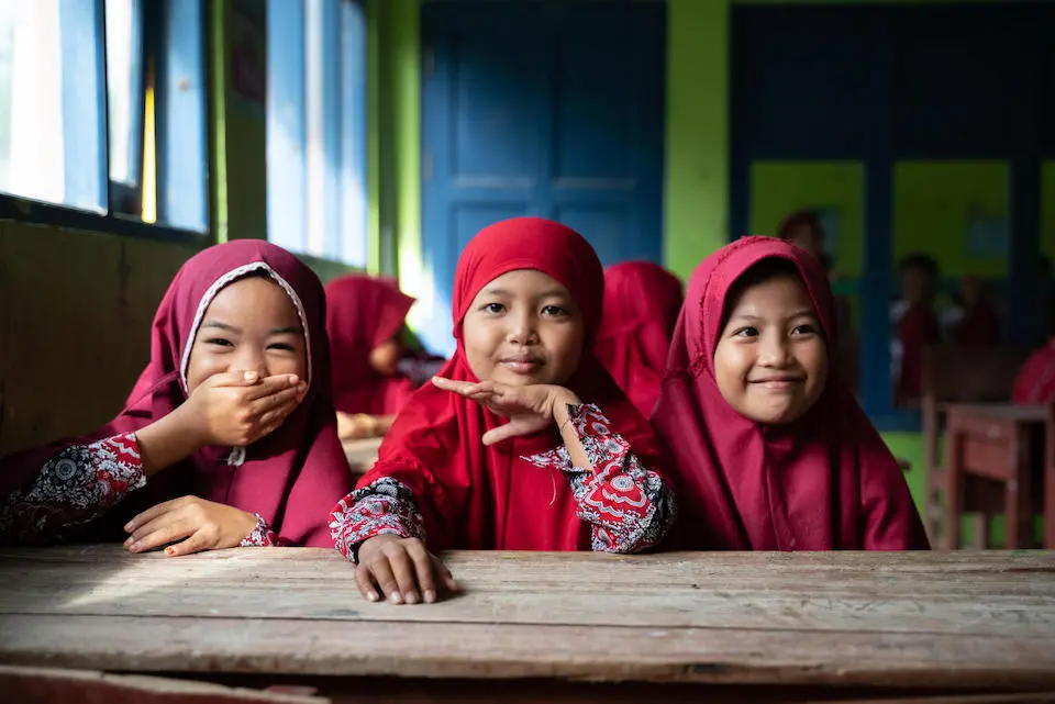 In Indonesia, Second graders wait their turn to get immunized at school, part of an effort to reverse the backslide in childhood vaccinations.