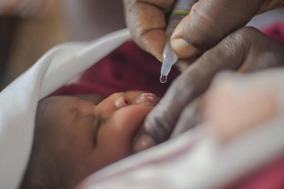 A midwife administers the polio vaccine to a baby at Ogur Health Center IV in Uganda's Lira District.