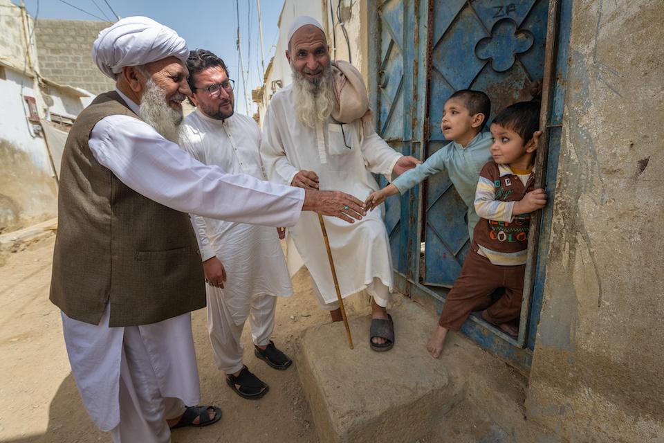 A tribal leader of the Pashtun community in Karachi, Pakistan, joins a UINCEF-supported social mobilizer on a household visit to discuss the benefits of the polio vaccine.