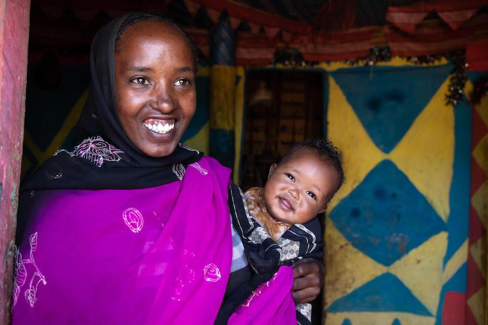 A mother in Ethiopia holding her 5-month-old baby, who is healthy and happy and well nourished thanks to breastfeeding and with help from a UNICEF malnutrition prevention program.