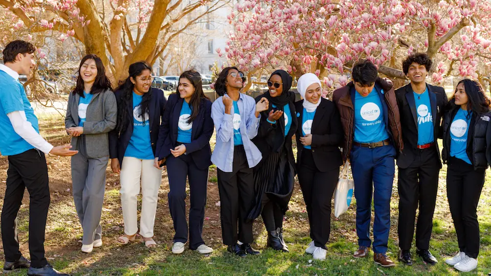 The 2022-23 UNICEF USA National Youth Council in front of magnolia trees at the National Mall.