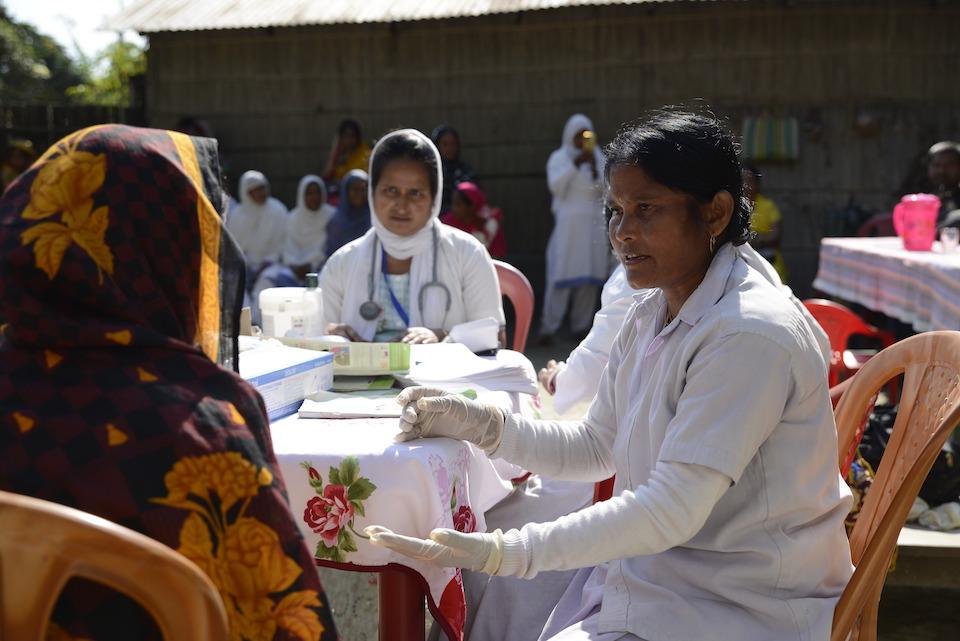 Health worker Parmeswari Adhikari discusses the importance of vaccines with a woman in Fulkakata village, Dhubri district, Assam, India.