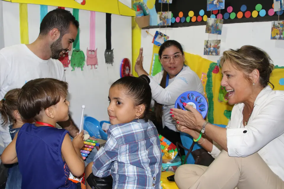 Children play a game with UNICEF staff and Education Cannot Wait Executive Director Yasmine Sherif, far right, at the PIO center in Cúcuta, Colombia.
