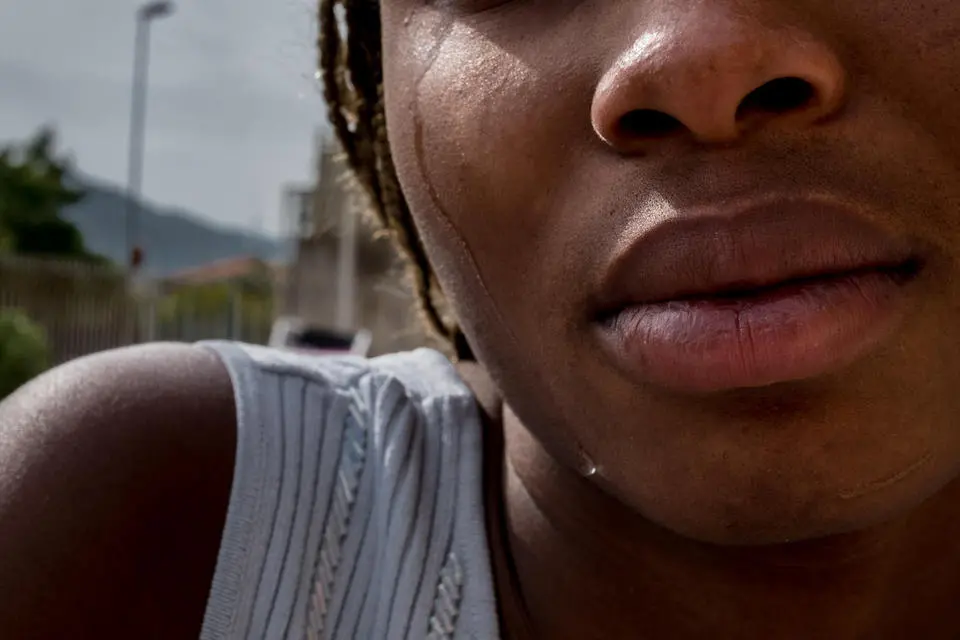 Mary, 18, from Benin City in Nigeria, cries outside the safe house where she now lives, on the outskirts of Taormina in Sicily.