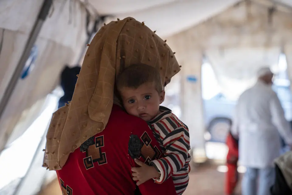 A mother hugs her child during a checkup at the UNICEF mobile health clinic in Al-Zhuriah makeshift camp, Rural Homs, Syria, on Sept. 27, 2022.