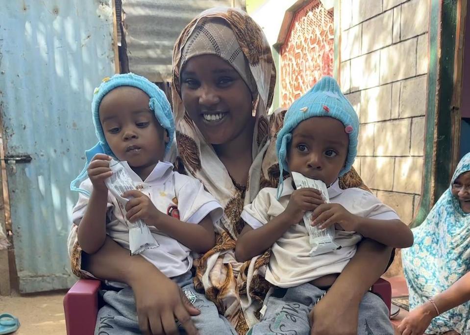 On May 2, 2023, mother Sadia Aden, 23, holds her 2-year-old twin boys, Khalil and Khalid Muktar, on her lap at their home in Garissa, Kenya.