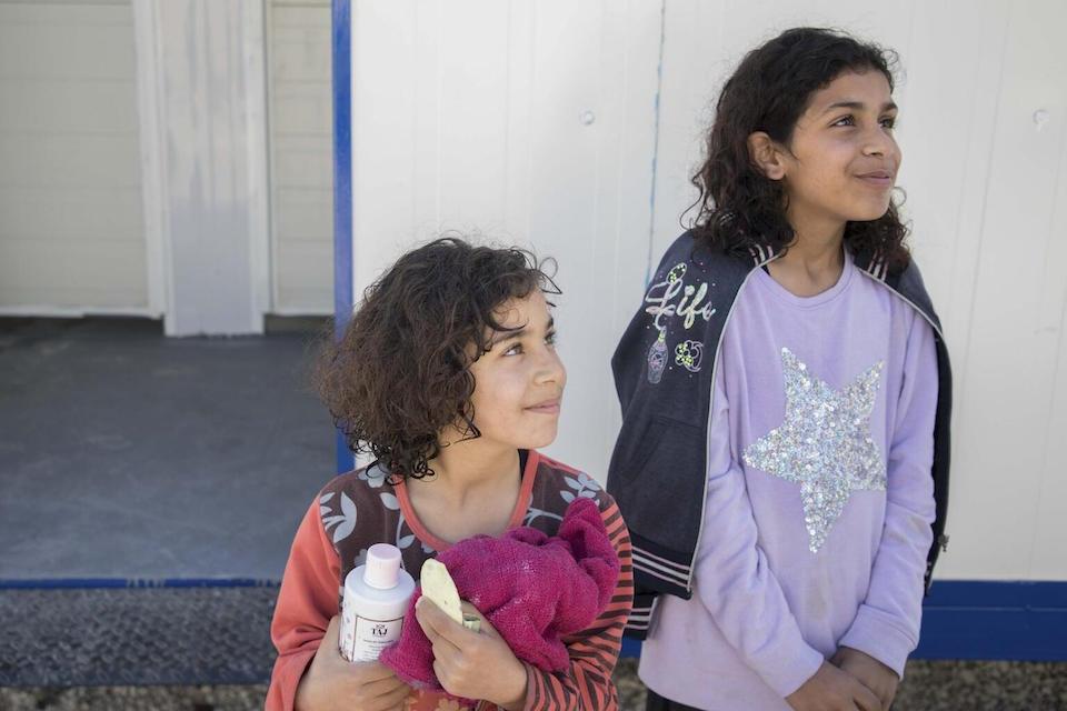 Sidra, 10, and Huda, 9, after taking a shower in the prefab bathrooms, provided by UNICEF, at the sports city in Lattakia, Syria, on March 9, 2023.