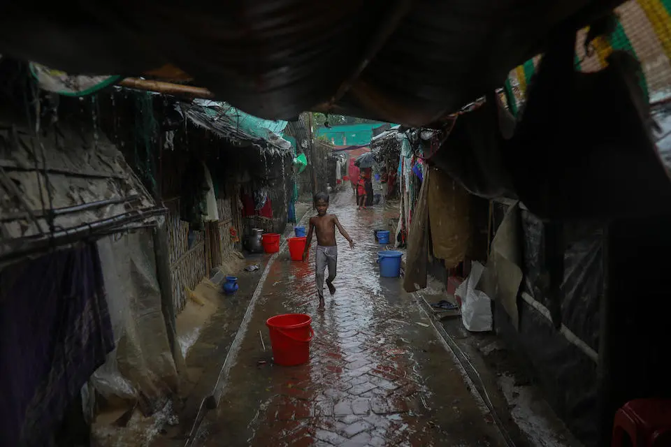 A child runs for shelter during Cyclone Mocha in Bangladesh on May 14, 2023l