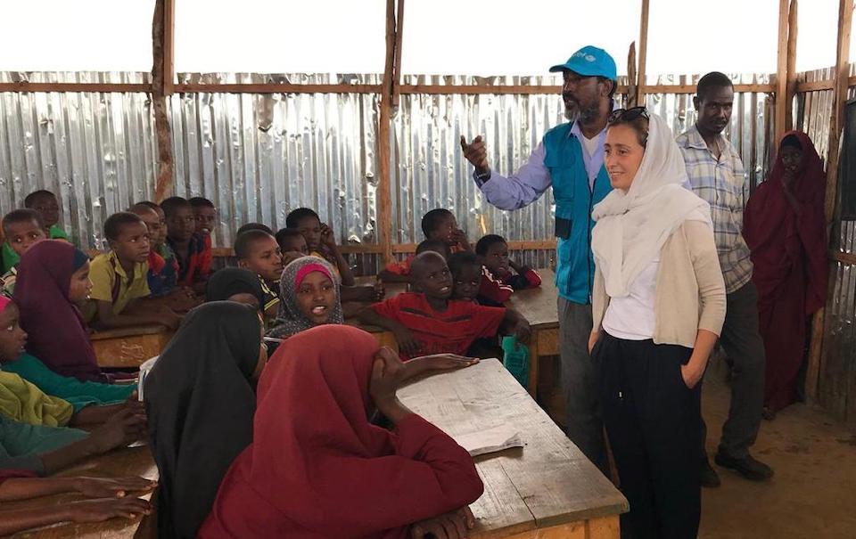 Sara Bordas Eddy alongside a UNICEF education officer in in a classroom full of students during a mission to Somalia in 2018.