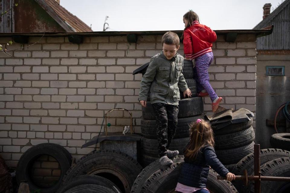 Three of Yevhenia's five children in the yard of their house in Kherson, Ukraine.