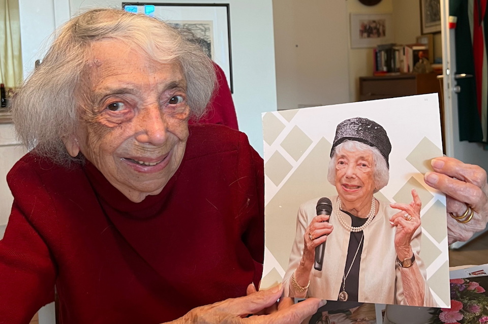 Margot Friedlander in Berlin, with a photo of the outfit she wore on her 100th birthday.