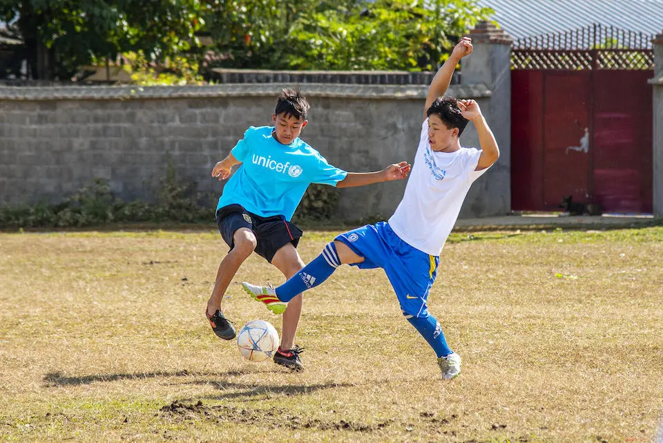 Children displaced by conflict in Myanmar come together to play football during the World Children's Day celebration organized by UNICEF and local partners in Mone Koe, Northern Shan State.