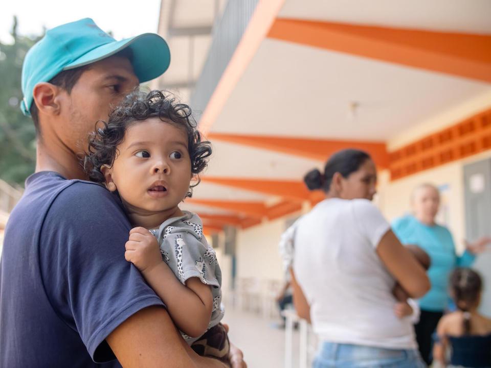 Noe Rodriguez, 8 months old, is carried by his father during a UNICEF-supported comprehensive day in Las Tejerías, Aragua state, Venezuela, on May 18, 2023.